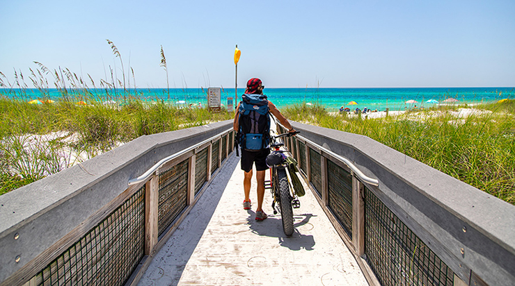 Cyclist on a beach boardwalk along 30A