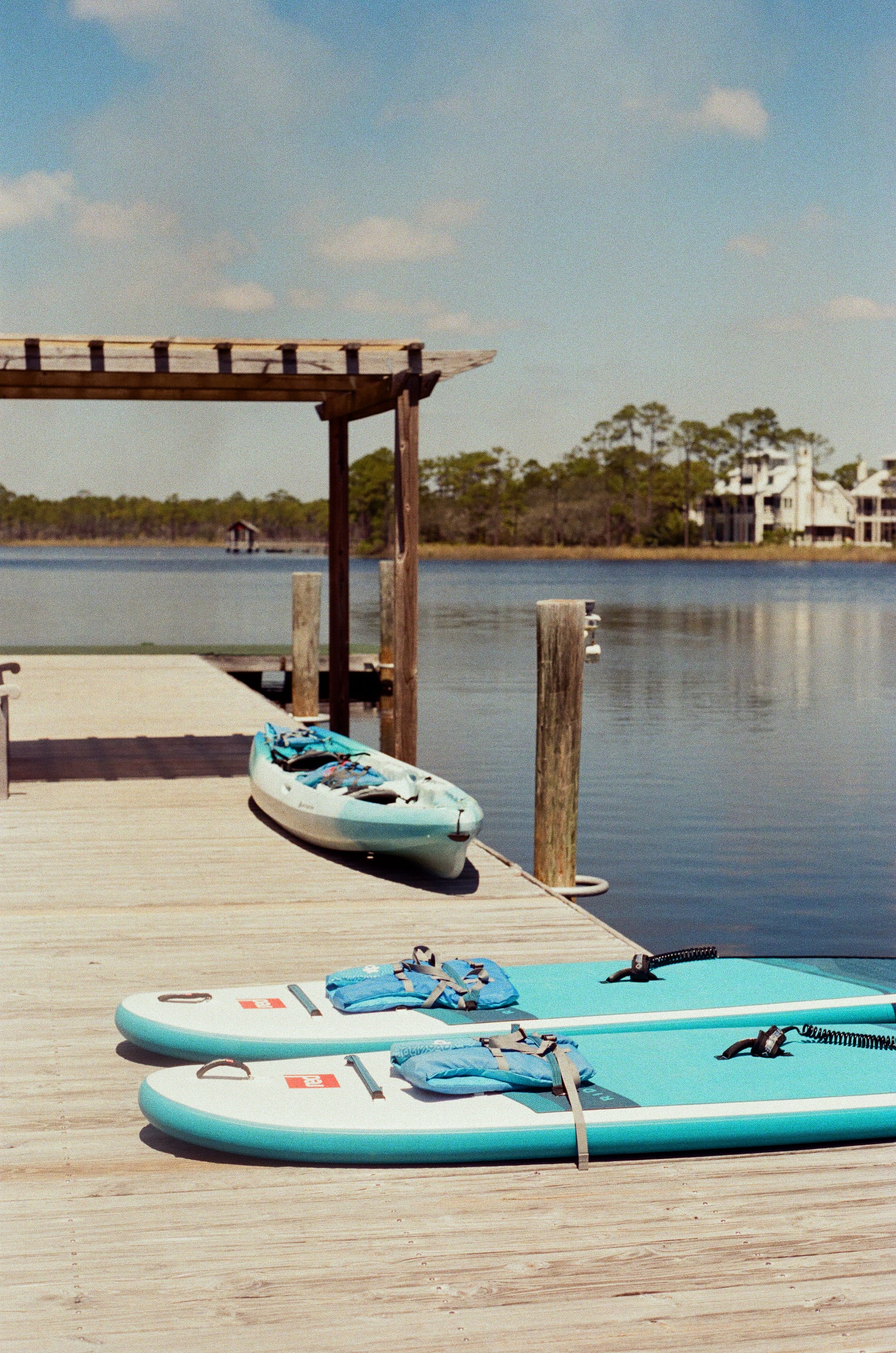 Stand-up paddleboards lined up on the dock at Boathouse Paddle Club