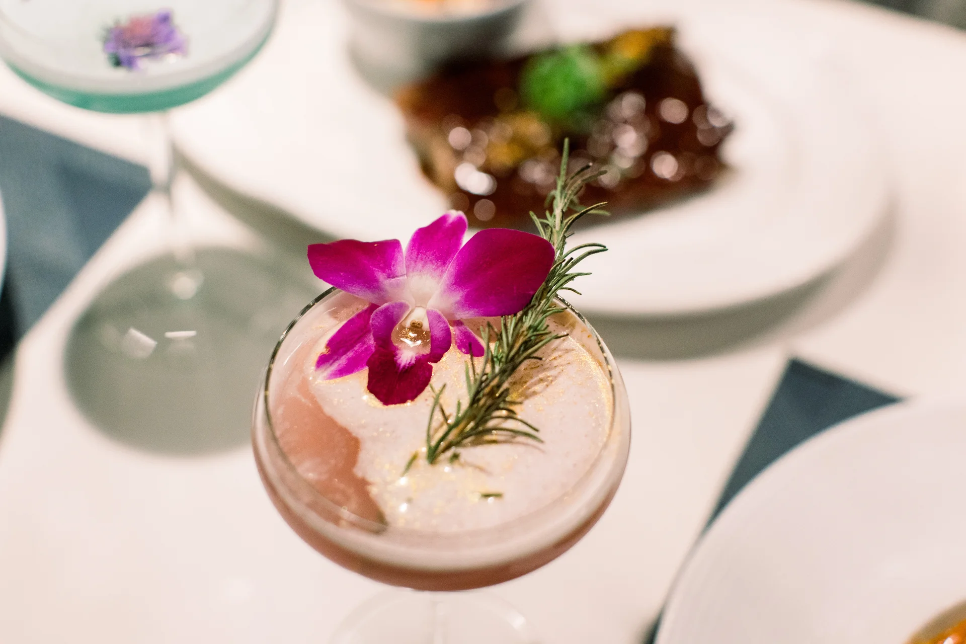 Craft cocktail at Aja 30A garnished with orchid and rosemary