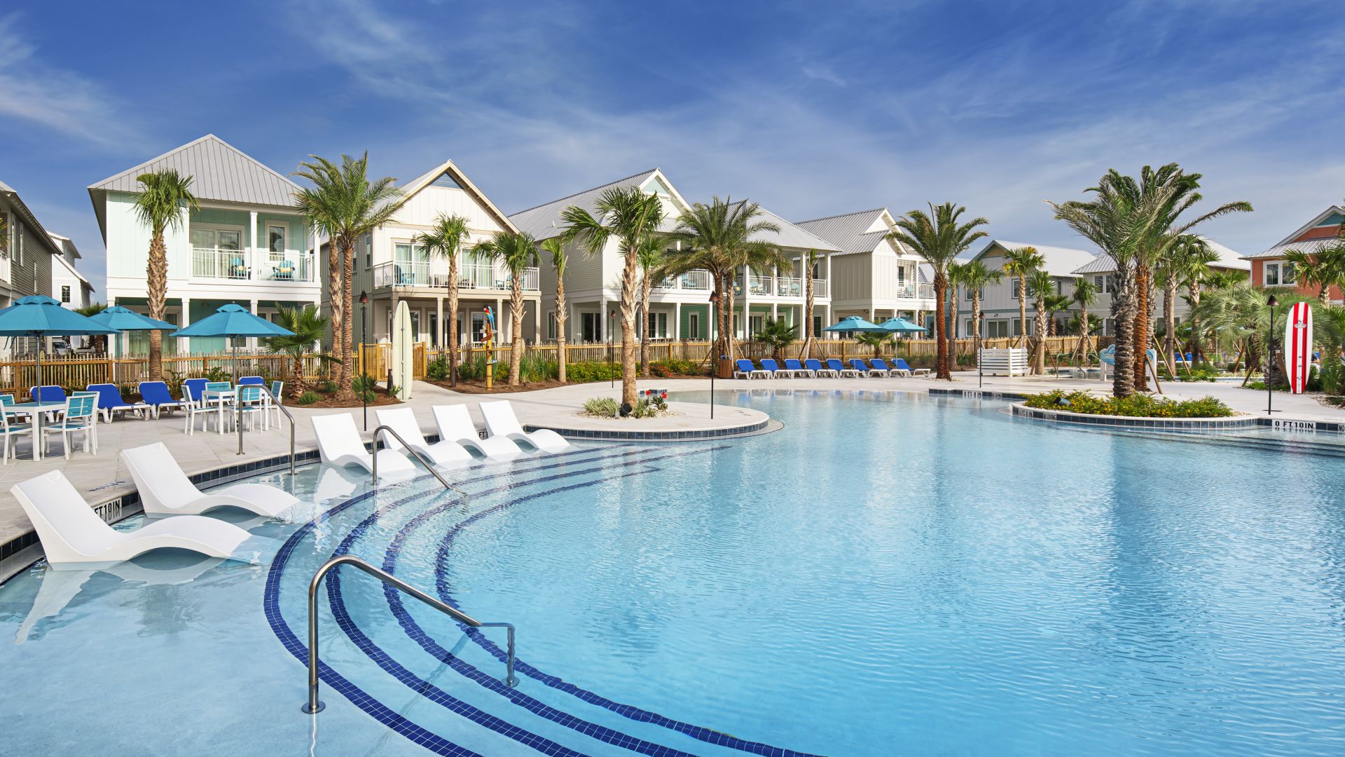 Pool area with vacation homes and palm trees at Margaritaville Beach Cottage Resort
