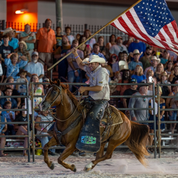 Riders and crowd at the Bulls on the Beach rodeo hosted on Flora-Bama's beach