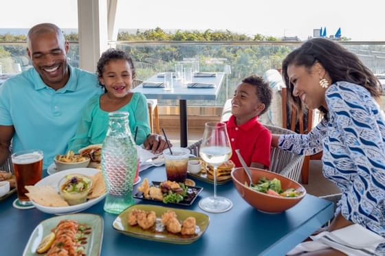 Family enjoying a meal on the patio at Fish Out of Water in WaterColor