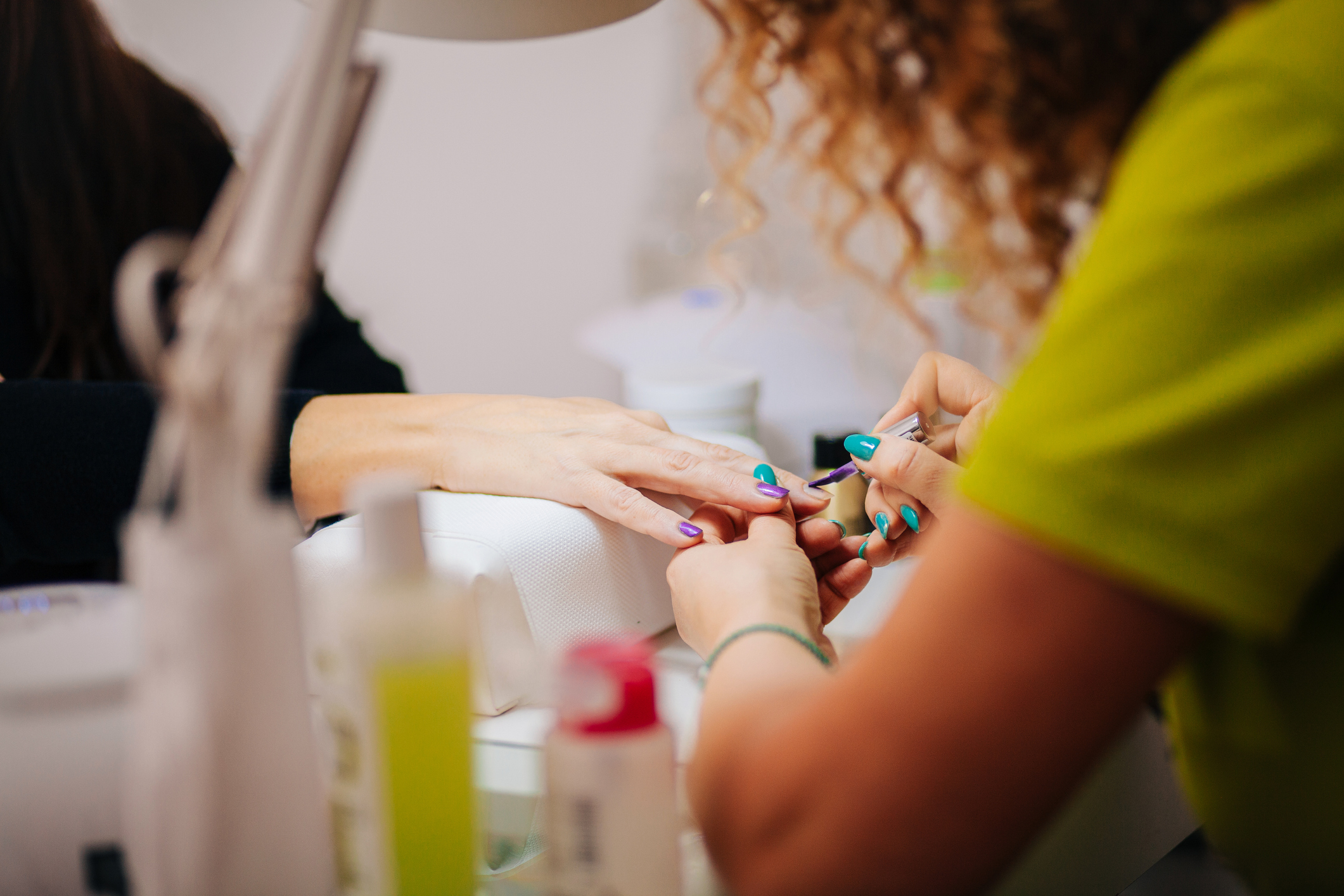Hands receiving a manicure and pedicure treatment at a nail salon