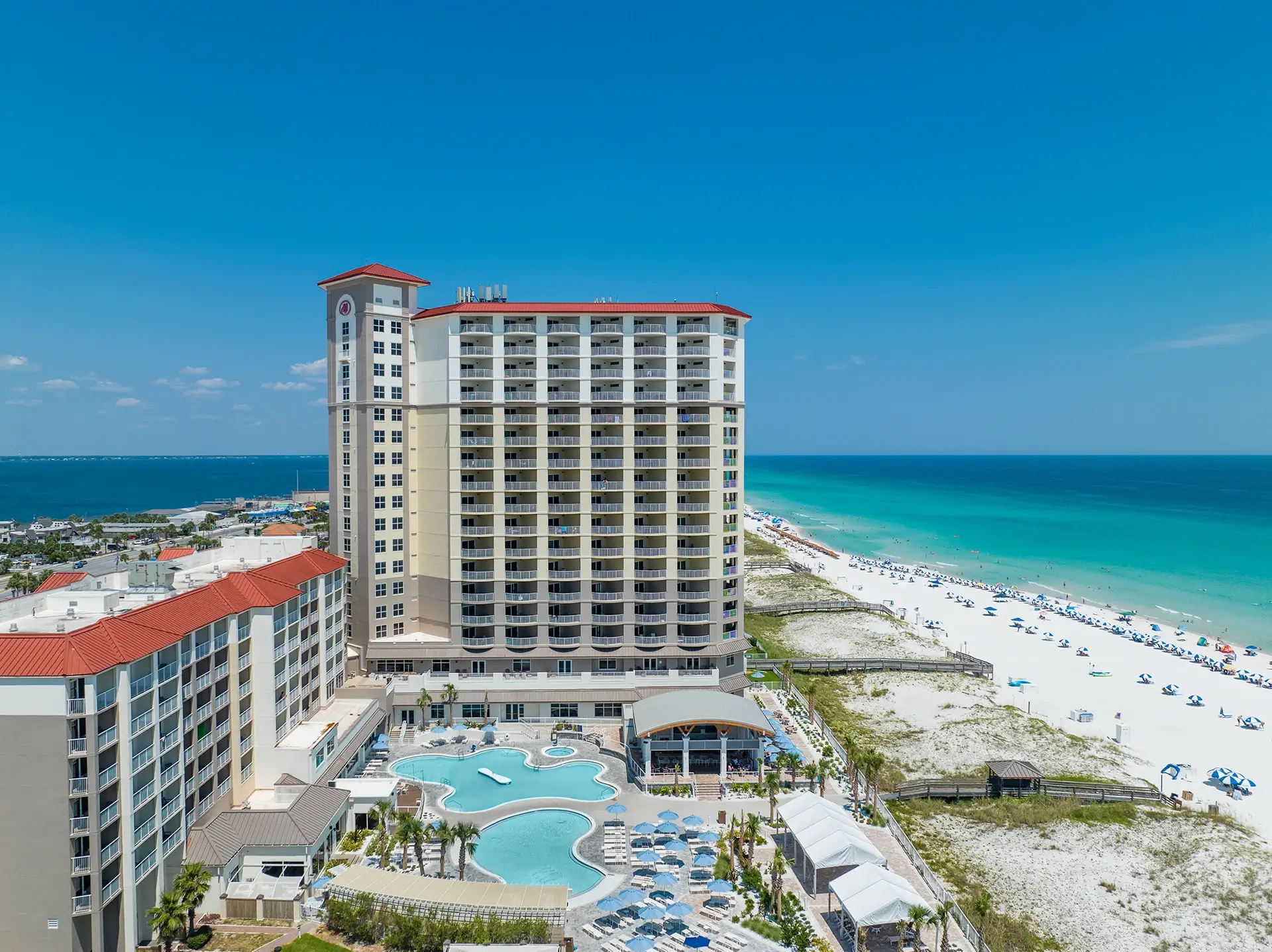 Aerial drone view of Hilton Pensacola Beach's tower and Gulf-front pools