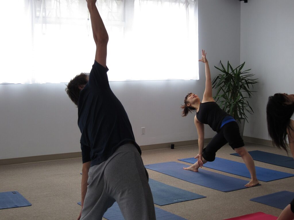 Students holding a standing stretch during a hatha yoga class