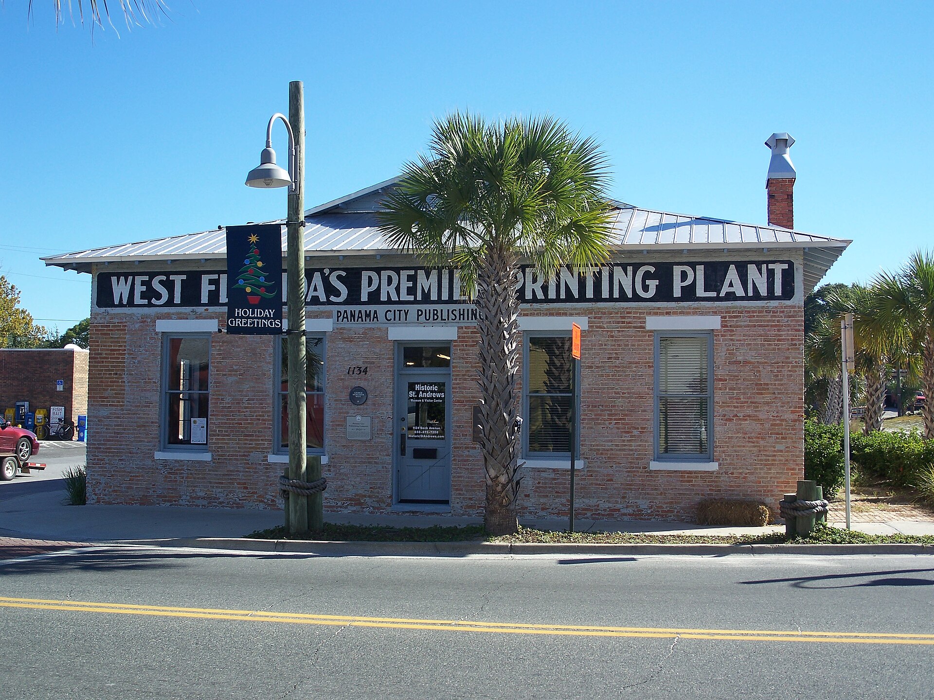 The historic Panama City Publishing Company building with a palm tree out front