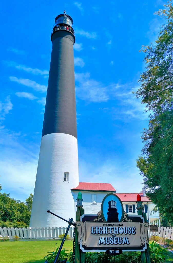 The Pensacola Lighthouse tower rising above the lighthouse and museum sign