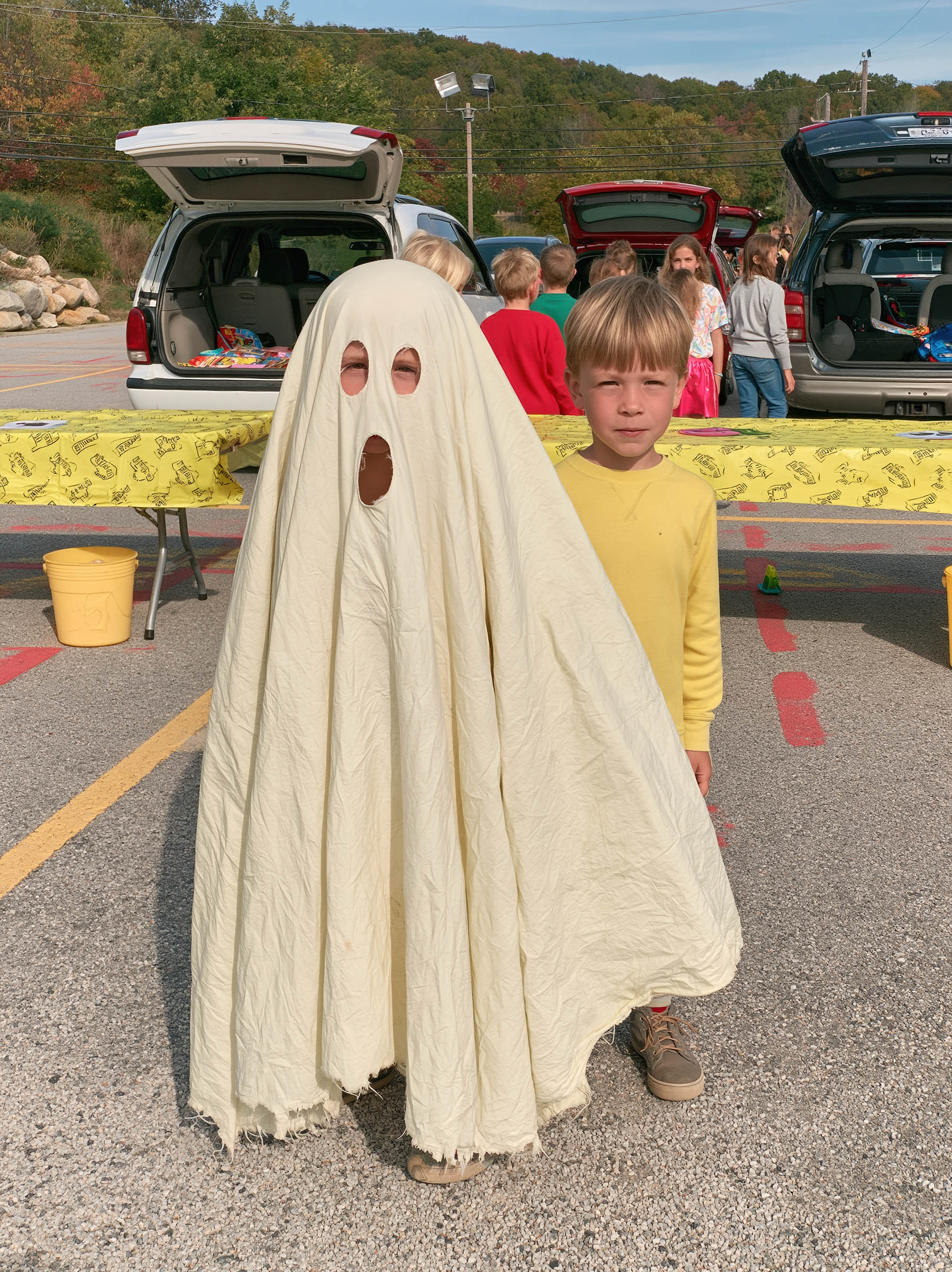 Child in a homemade sheet ghost costume at a trunk-or-treat event