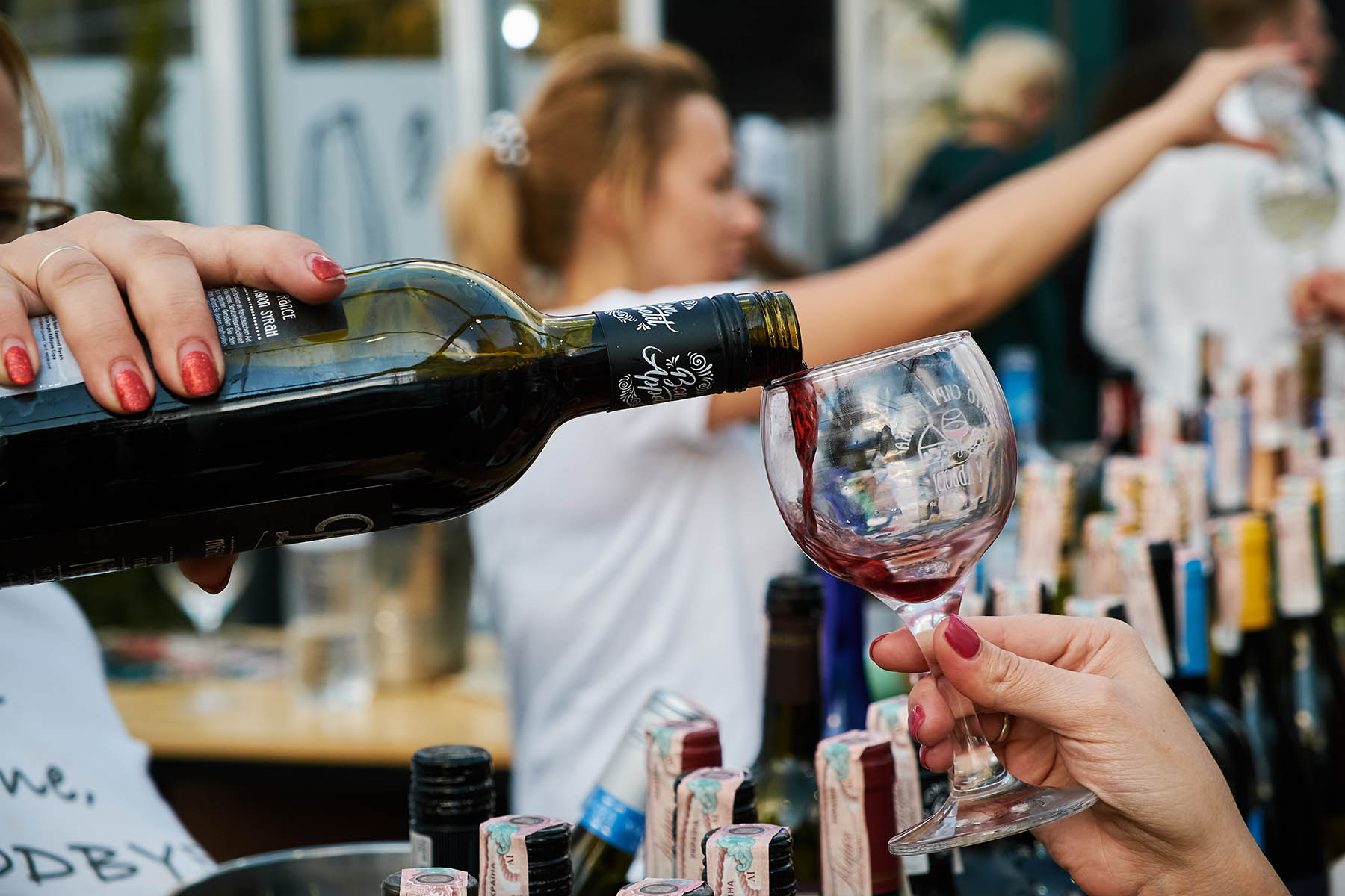 Wine being poured into a glass at a tasting