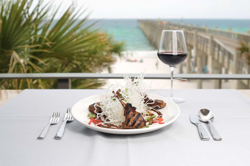 A plated entree at DRIFT with the Gulf Pier in the background